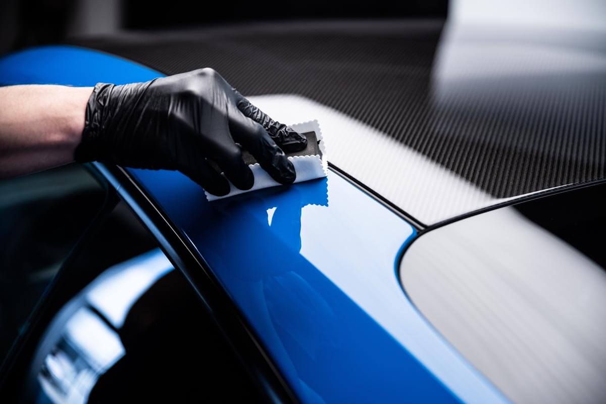 Technician installing a ceramic coating using an applicator pad